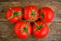 Red ripe and bright tomatoes wooden background