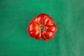 Red ripe Bull`s Heart Heirloom Tomato whole top view isolated agains green paper background Royalty Free Stock Photo