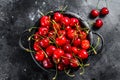 Red ripe cherries in a colander. Black background. Top view Royalty Free Stock Photo