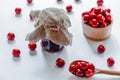 Red ripe cherries with jam jar and wooden spoon on white background. Flat lay. Food concept. Royalty Free Stock Photo