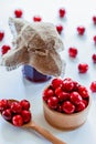 Red ripe cherries with jam jar and wooden spoon on white background. Flat lay. Food concept. Royalty Free Stock Photo