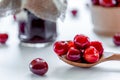 Red ripe cherries with jam jar and wooden spoon on white background. Flat lay. Food Royalty Free Stock Photo