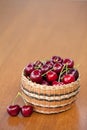 Red Ripe Cherries in a basket on a wood table Royalty Free Stock Photo