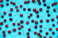 Red ripe cherry berries on blue background. Cherry pattern. Flat lay. Healthy food concept Royalty Free Stock Photo