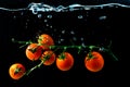 Red cherry tomatoes under water with bubles on black Royalty Free Stock Photo