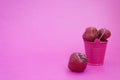 Red ripe fresh strawberries on a pink background lies in a pink bucket. spilled from a bucket of ripe strawberries