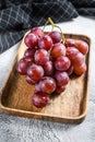 Red ripe grapes in a wooden bowl. White background. Top view Royalty Free Stock Photo