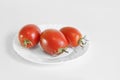 Red ripe juicy tomatoes on a white plate. Royalty Free Stock Photo