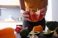 Red ripe pepper cut in half in female hands in kitchen Royalty Free Stock Photo