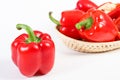 Red ripe peppers with wicker basket on white background, healthy nutrition Royalty Free Stock Photo