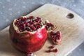 Red ripe pomegranate on wooden cutting board. Fresh open ruby garnet on table. vitamin and diet concept. Juicy tropical fruit