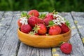 Red ripe strawberries in a wooden basket on the old boards on the background Royalty Free Stock Photo