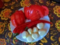 Red ripe tomatoes chili peppers and peeled garlic on a white plate Royalty Free Stock Photo