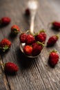 Red ripe wild strawberry in old vintage spoon on the rustic background Royalty Free Stock Photo