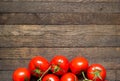 Red ripened tomatoes on wooden background with copy space at top