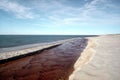 The red river flows into the blue sea Royalty Free Stock Photo