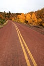 Red road in autumn scenery Royalty Free Stock Photo