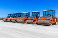 Red road rollers parked on the unfinished road construction site