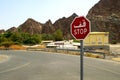 Red road stop sign in Arab language along a crossroad in UAE or Oman