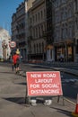 A red roadwork sign saying new road layout for social distancing on an empty street in London
