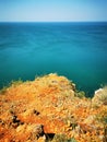 Red rock cliff , blue sea and clear sky Royalty Free Stock Photo