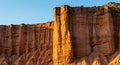 Red rock cliffs illuminated by sunlight, forming a dramatic landscape. The rock Royalty Free Stock Photo