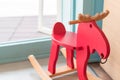 Red rocking horse toy for kid in home living room, cheerful riding stuff for children playing on the wooden floor in nursery, Royalty Free Stock Photo