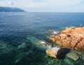 Red Rocks called Rocce Rosse at mediterranean sea coastline in Arbatax with two boys fishing. Tortoli, Ogliastra