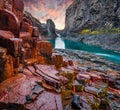 Red rocks cliff in deep canyon of mountain river. Fantastic autumn sunrise on Studlagil Canyon. Impressive morning landscape of Jo