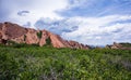 Red rocks in the green park with clouds Royalty Free Stock Photo