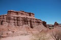 The red rocks of sandstone stand on desert area against blue sky background