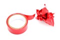 Red roll and a lump of crumpled used electrical sticky isolation duct tape on white background