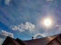 Red roof and blue sky with glowing sun ray scenery