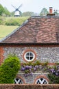 Roof of characterful cottage in the village of Turville in the Chilterns, with Cobstone Mill at the top of the hill behind.