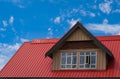 Red roof with dormer in the blue sky background. Decorative metal roof. Types of roof roofs. Roofing Royalty Free Stock Photo