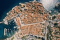 Red roofs of ancient houses in the port with moored boats. Dubrovnik, Croatia. Drone