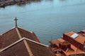 Red roofs with cross on river Douro background top view. Embankment with church roof and wooden cross in Porto, Portugal. Royalty Free Stock Photo