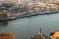 Red roofs with cross on river Douro background top view. Embankment with church roof and wooden cross in Porto, Portugal.