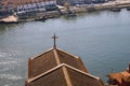 Red roofs with cross on river Douro background top view. Embankment with church roof and wooden cross in Porto, Portugal.