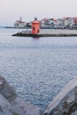 Red roofs of the historical center of old town Piran with beautiful lighthouse against the sunrise sky and Adriatic sea.