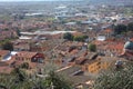 The red roofs of the inhabited houses, the church and the bell tower of the pietrasanta cathedral seen from the green of a hill at