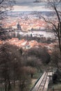 Red rooftops of old city of Prague viewed through leafless trees on a cloudy day of summer. Romantic Prague postcard in Royalty Free Stock Photo