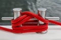 Red rope fasten on stake of yacht