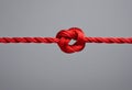 Red rope knot creating connection and problem solving Royalty Free Stock Photo