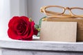 Red rose and blank brown paper on vintage cabinet Royalty Free Stock Photo