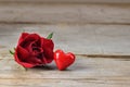 Red rose blossom and a heart shape from glass on rustic wood, love concept for Valentine`s or Mother`s Day, copy space, selected Royalty Free Stock Photo
