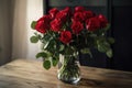 red rose bouquet in clear vase on wooden table