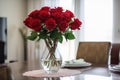 red rose bouquet in vase on dining table, setting the scene for a romantic dinner Royalty Free Stock Photo