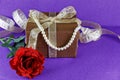 Red rose with brown present. Holiday theme Royalty Free Stock Photo