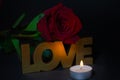 Red rose with candle and love written